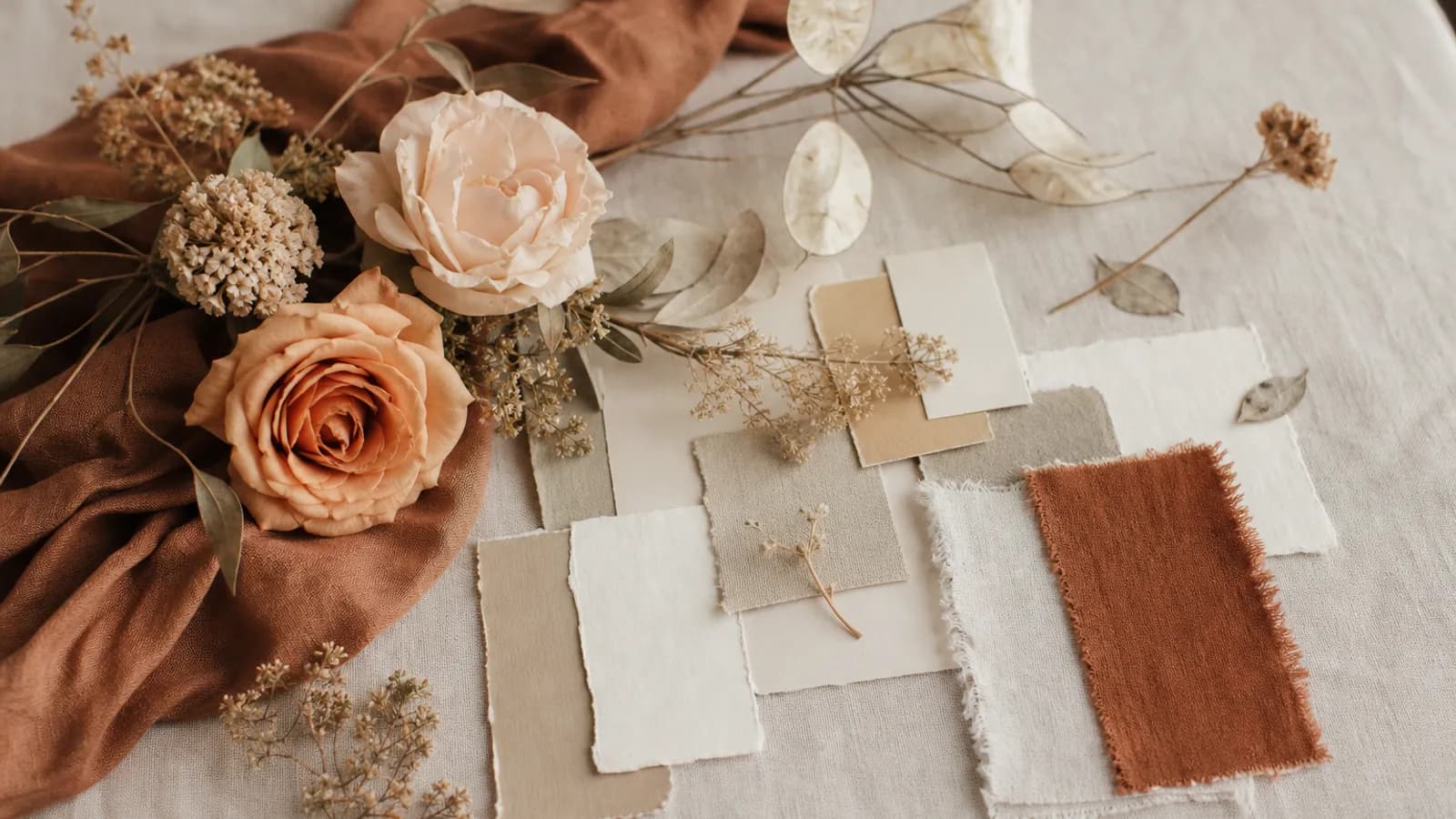A mood board for a wedding theme with fabric, flowers and color swatches